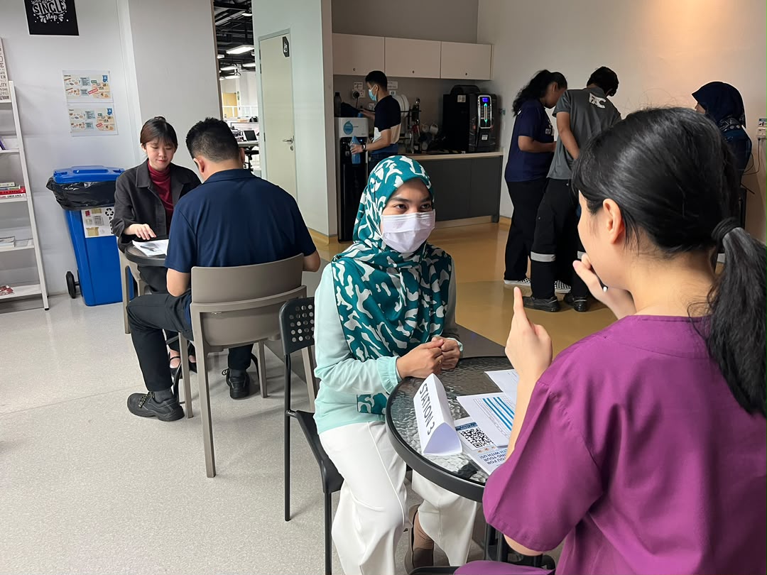 Employees receiving personalised health screening consultations from healthcare professionals during Evercare Medical Care Centre's workplace wellness programme at Qdos Batu Kawan.
