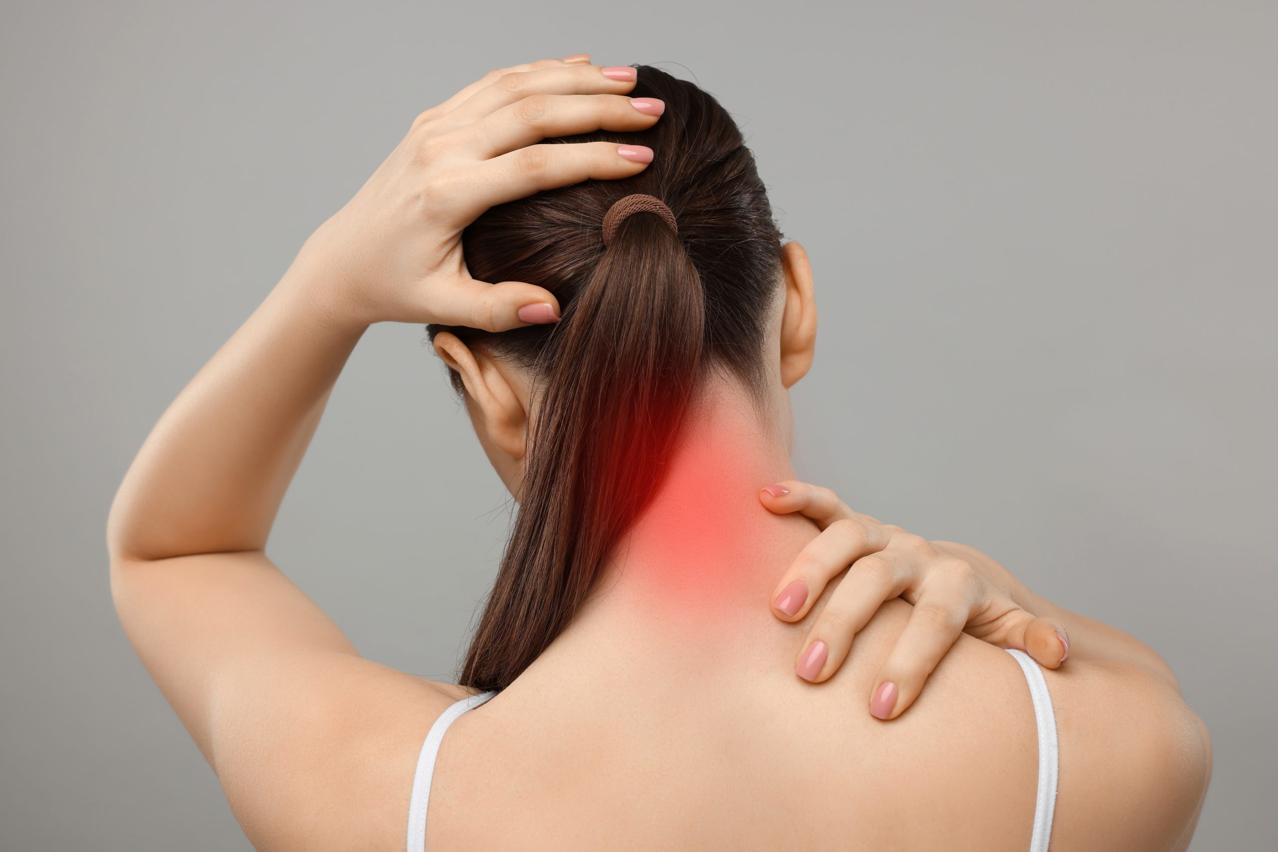 A person holding the back of the neck due to neck pain, illustrating cervical pain that may require orthopaedic assessment and treatment in Penang.