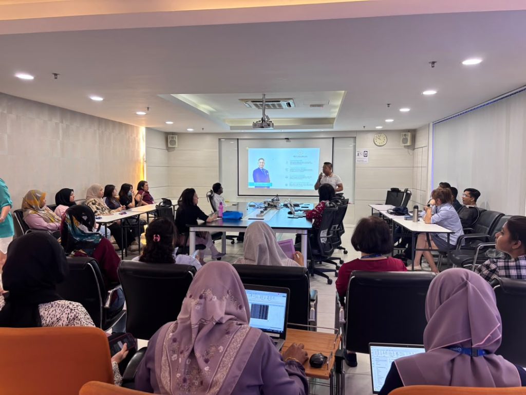 A health expert delivering a workplace wellness talk to employees during a corporate health education programme at Qdos in Penang.