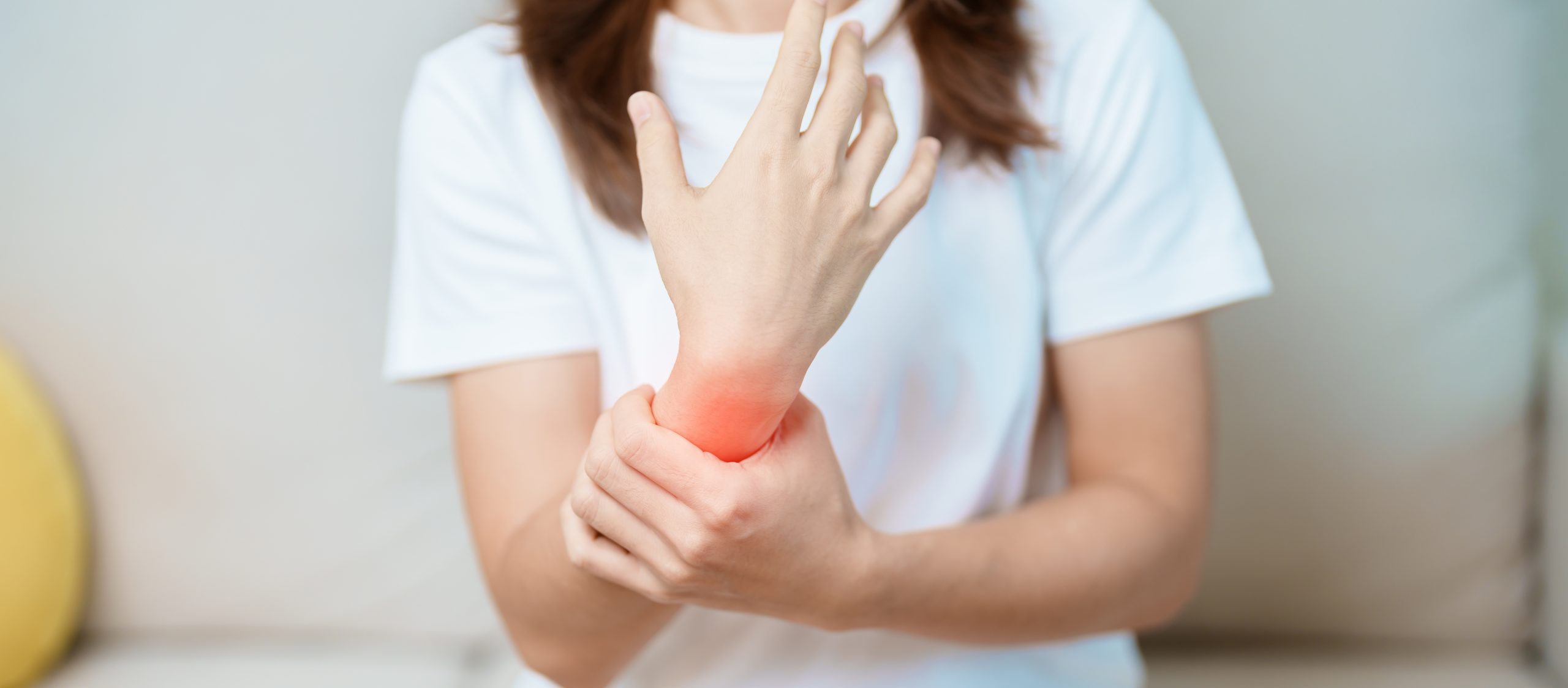 A person holding a painful wrist, illustrating wrist pain that may require orthopaedic assessment and treatment in Penang.