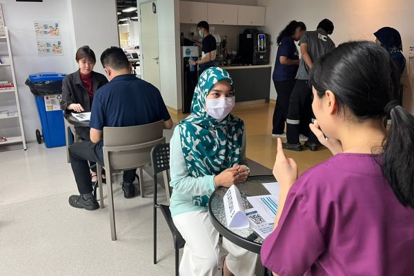 Employees receiving personalised health screening consultations from healthcare professionals during Evercare Medical Care Centre's workplace wellness programme at Qdos Batu Kawan.